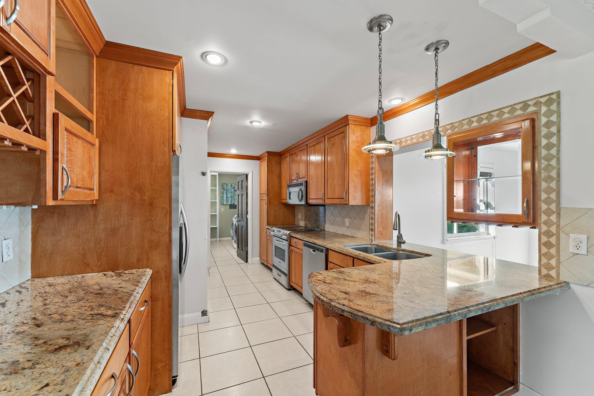 243 West Riverside Drive Jupiter, FL 33469 - Photo 21 of 67 a kitchen with stainless steel appliances granite countertop a sink and a refrigerator