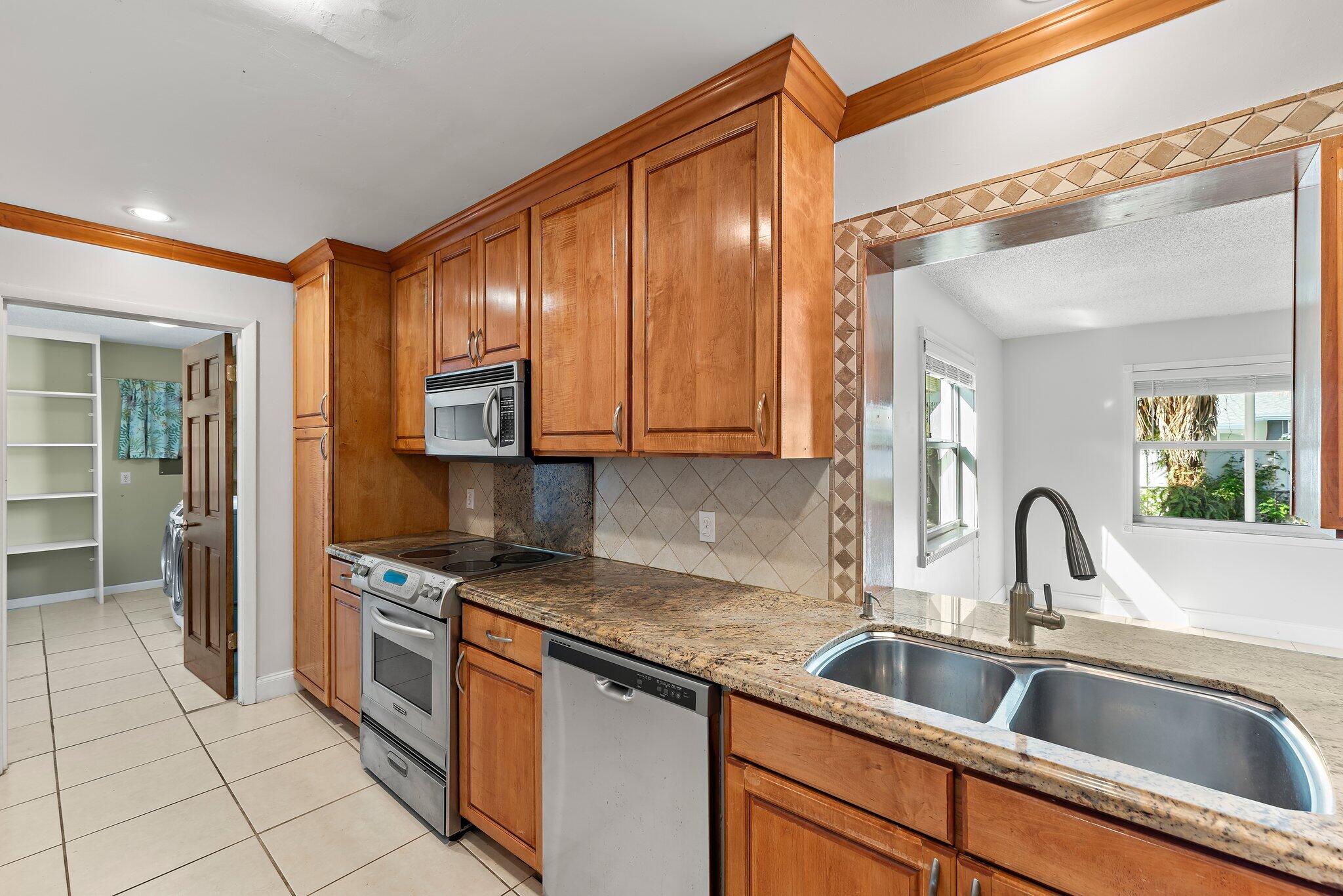 243 West Riverside Drive Jupiter, FL 33469 - Photo 22 of 67 a kitchen with stainless steel appliances granite countertop a sink stove and cabinets