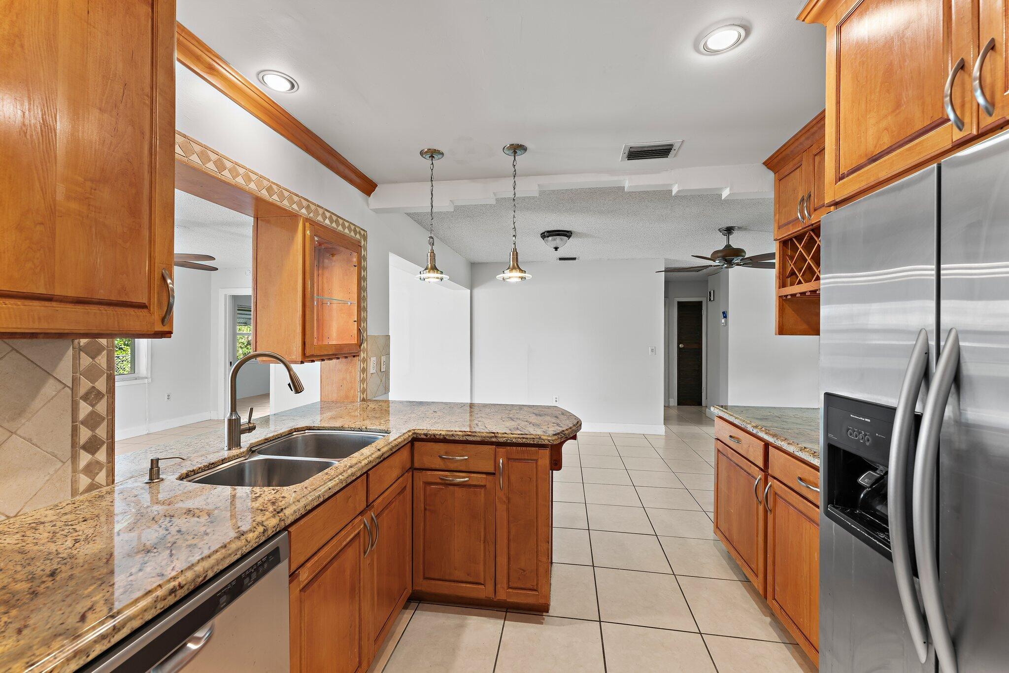 243 West Riverside Drive Jupiter, FL 33469 - Photo 24 of 67 a kitchen with granite countertop a sink a counter top space stainless steel appliances and cabinets