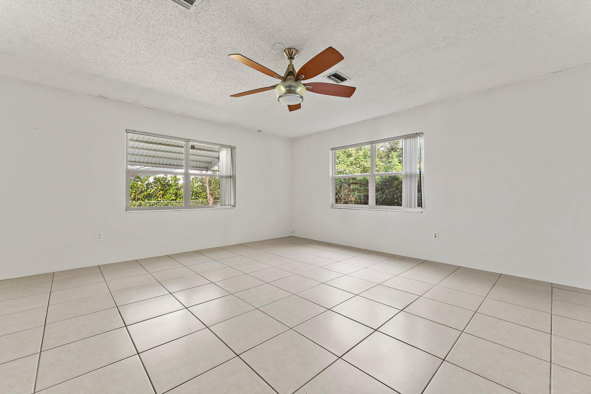 243 West Riverside Drive Jupiter, FL 33469 - Photo 27 of 67 an empty room with windows and ceiling fan