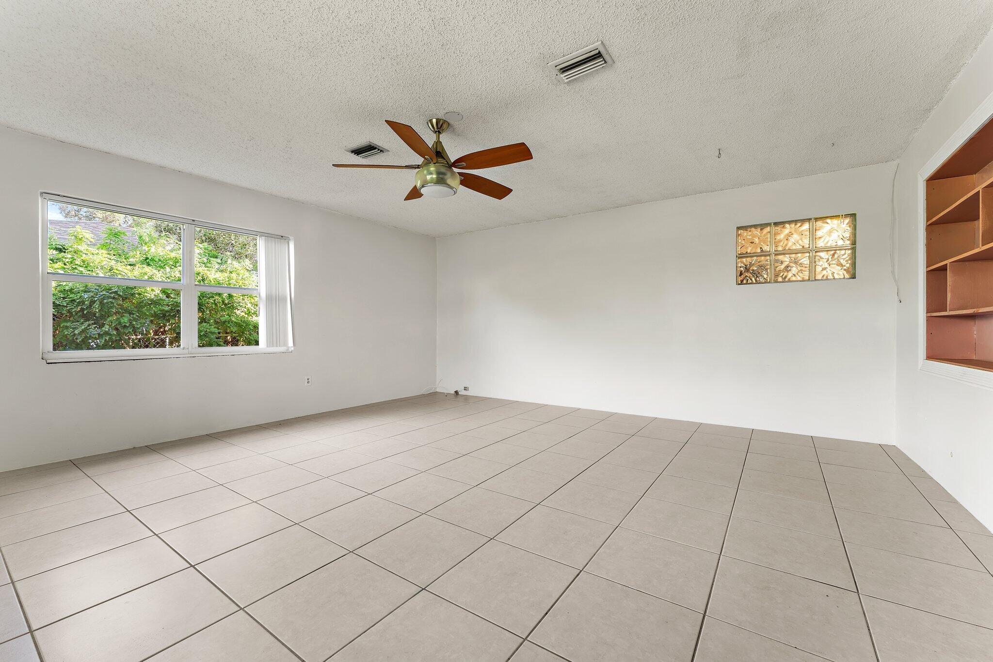 243 West Riverside Drive Jupiter, FL 33469 - Photo 29 of 67 an empty room with windows and ceiling fan