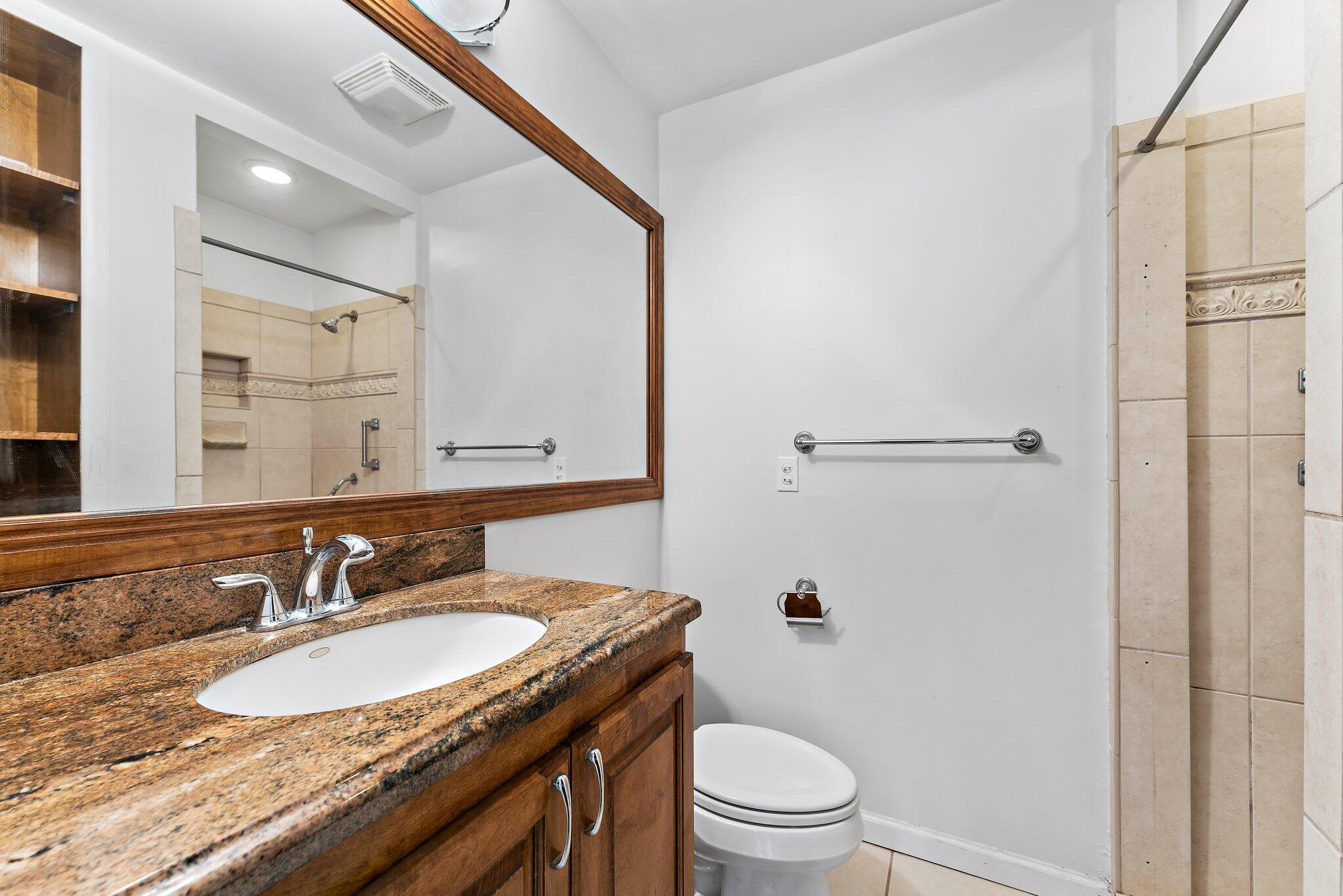 243 West Riverside Drive Jupiter, FL 33469 - Photo 37 of 67 a bathroom with a granite countertop sink toilet a mirror and shower