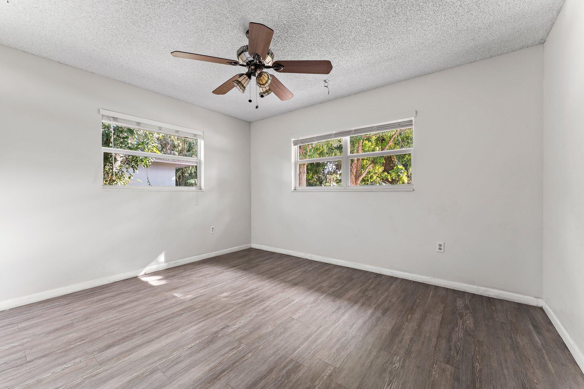 243 West Riverside Drive Jupiter, FL 33469 - Photo 39 of 67 a view of room with wooden floor ceiling fan and windows