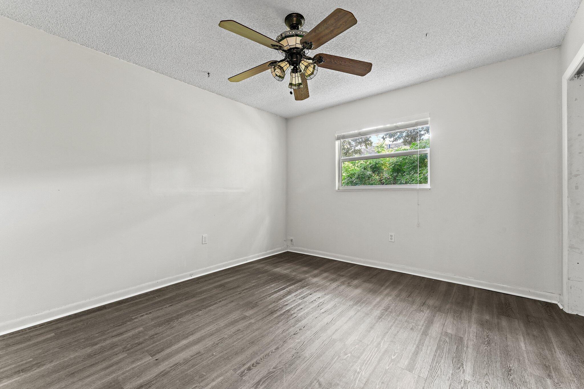 243 West Riverside Drive Jupiter, FL 33469 - Photo 41 of 67 an empty room with wooden floor and ceiling fan