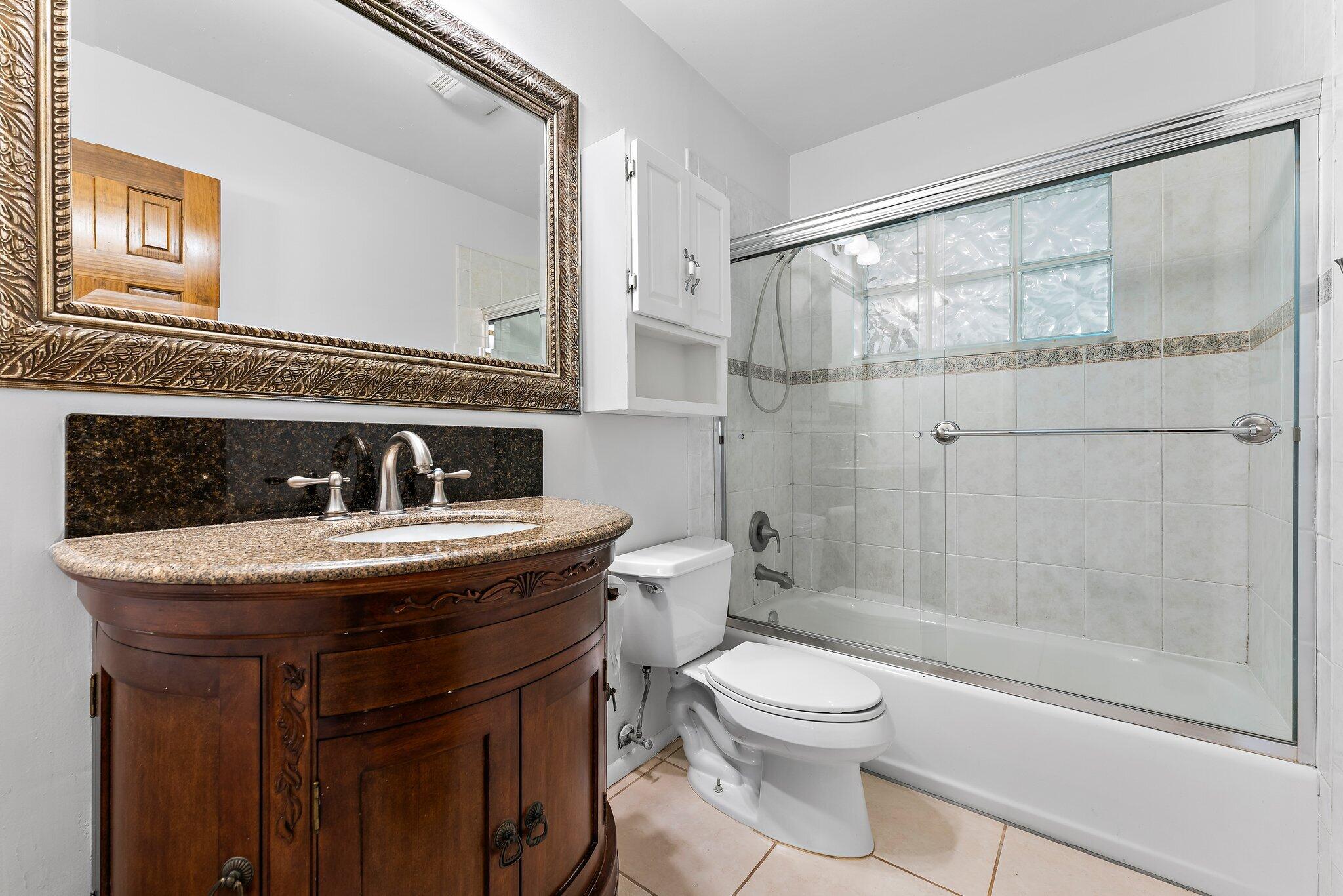 243 West Riverside Drive Jupiter, FL 33469 - Photo 43 of 67 a bathroom with a granite countertop sink a toilet and shower