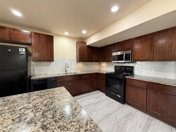 a kitchen with granite countertop stainless steel appliances and wooden cabinets