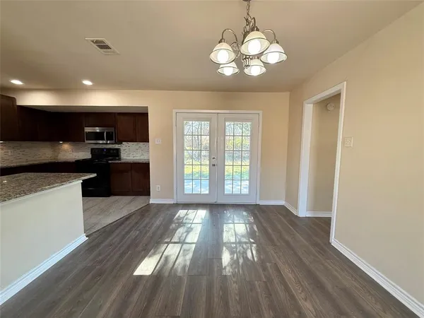 a view of kitchen with sink a microwave and cabinets
