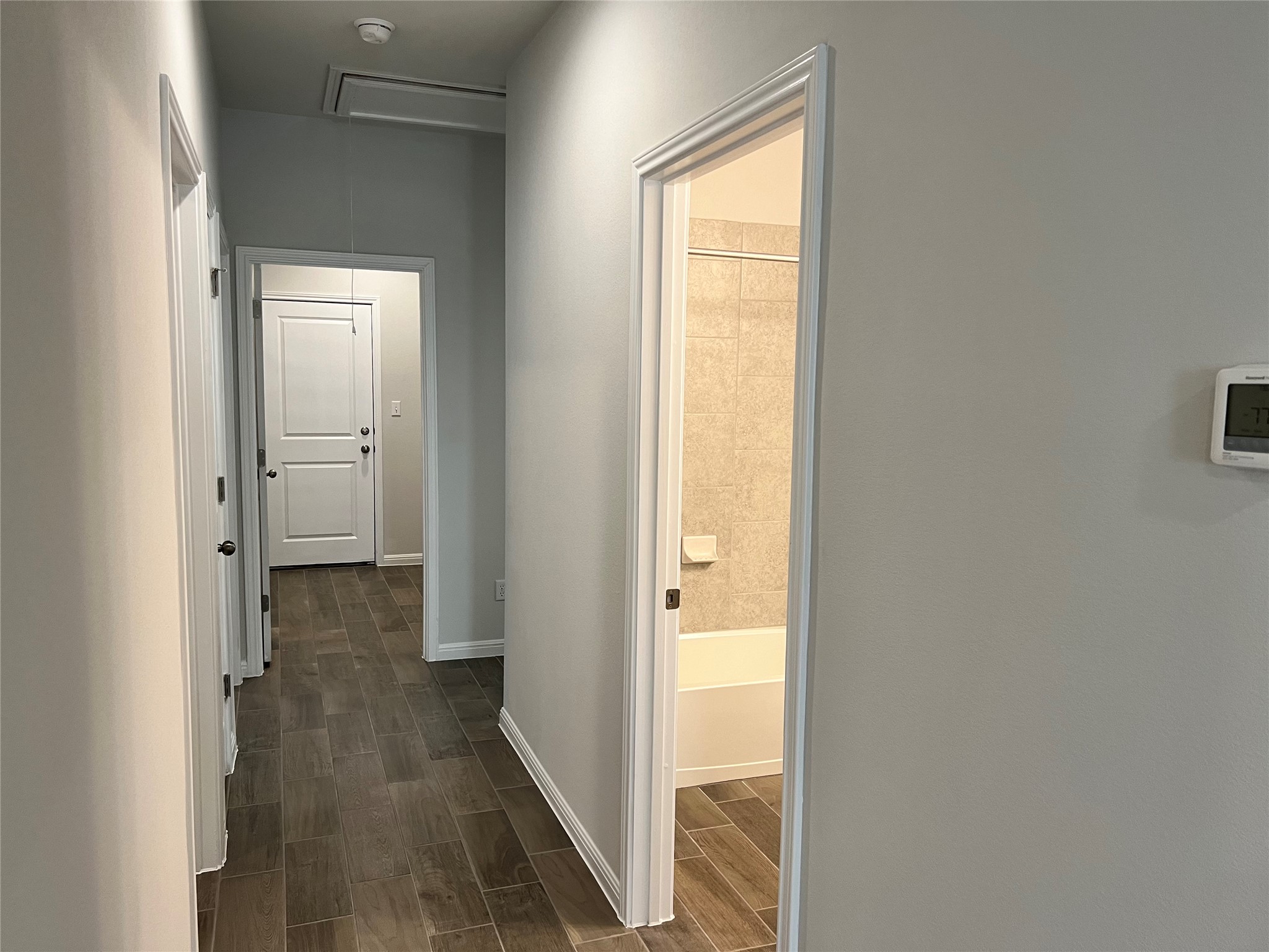 140 Pentro Path Georgetown, TX 78626 - Photo 16 of 37 Clean lines and a wood-look tiled floor define this inviting hallway.