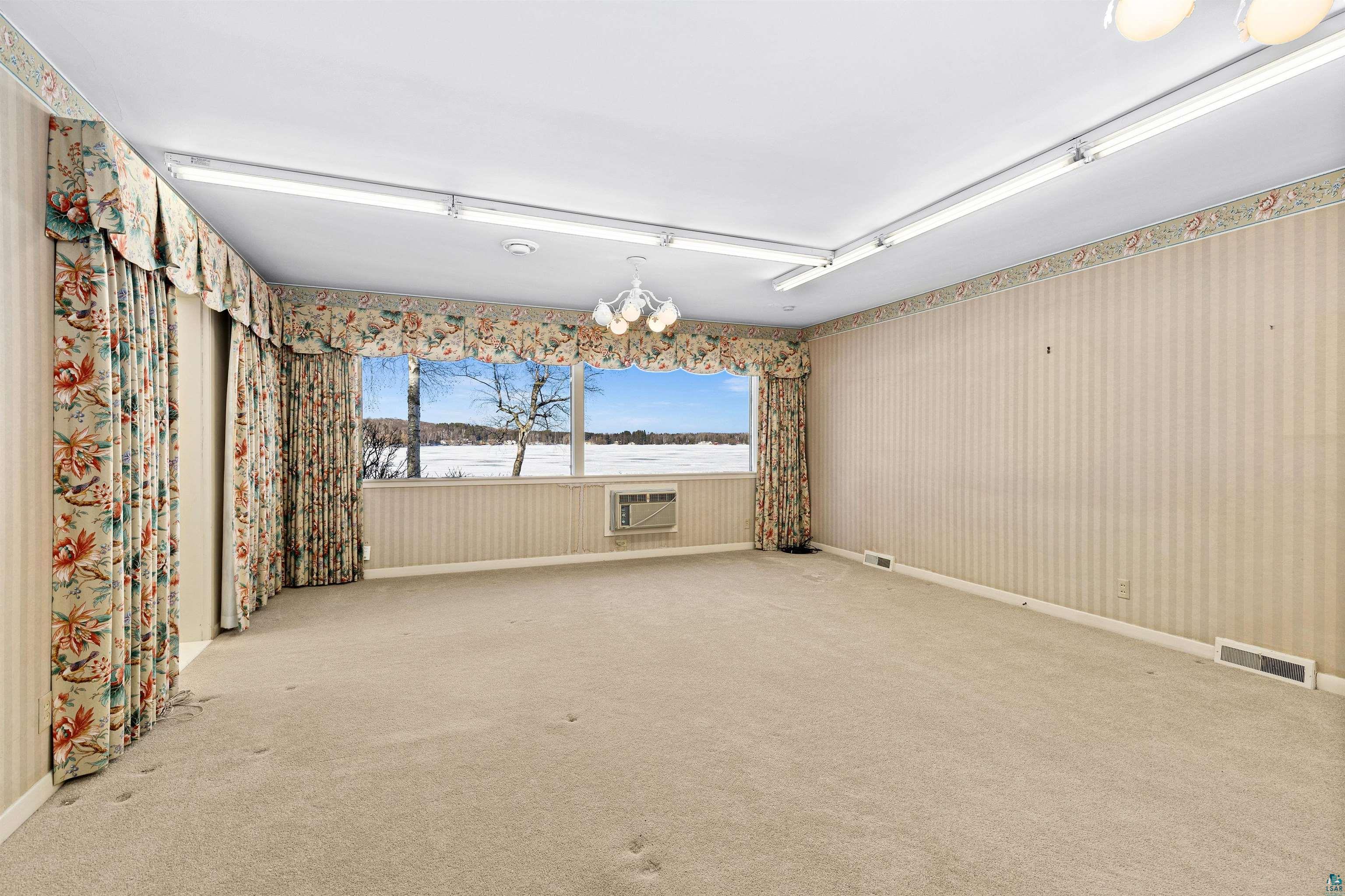5781 South Pike Lake Road Duluth, MN 55811 - Photo 15 of 42 Empty room with hanging lights and carpet