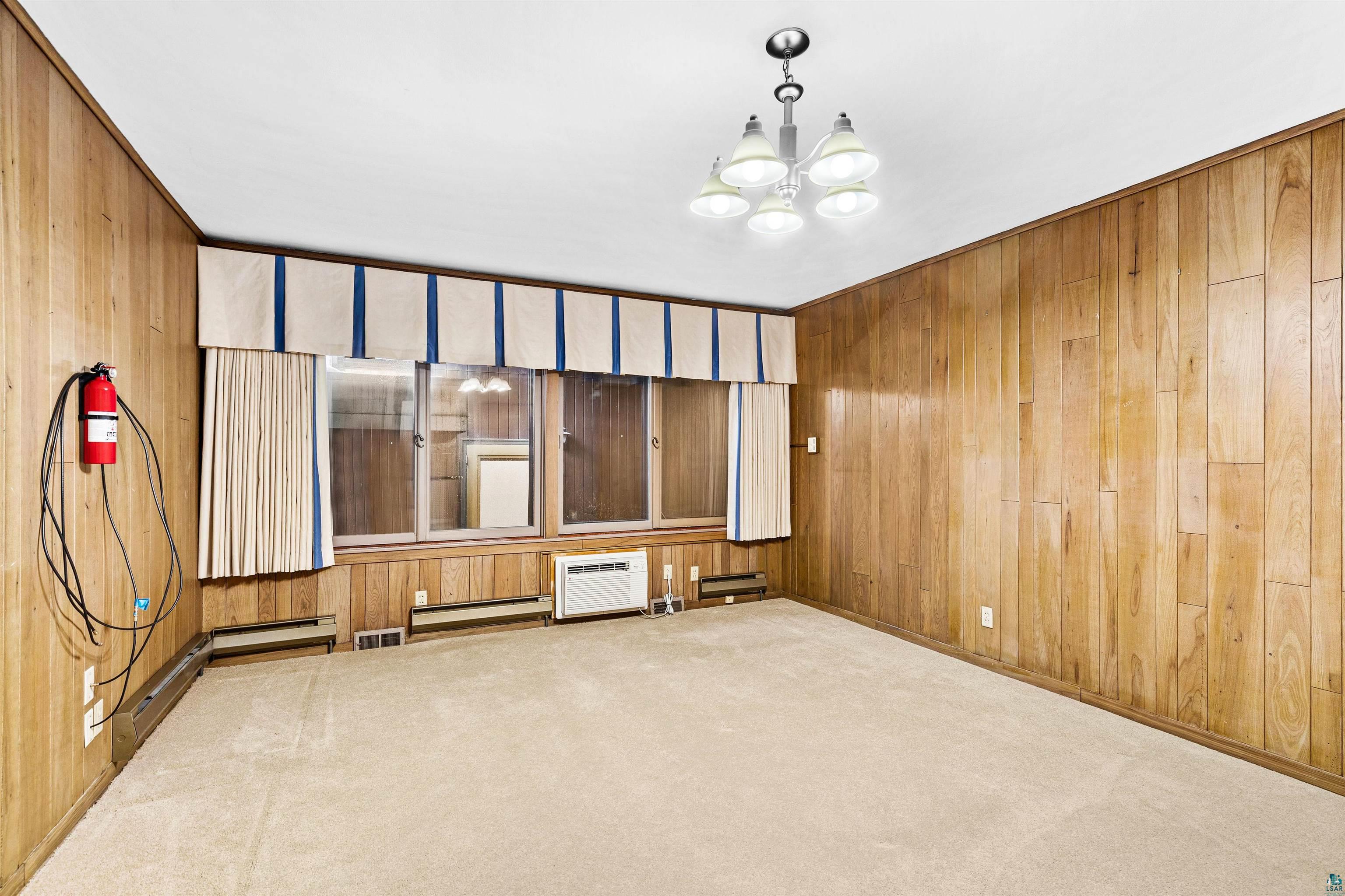 5781 South Pike Lake Road Duluth, MN 55811 - Photo 16 of 42 Unfurnished room featuring carpet floors, suspended lighting, and wooden walls
