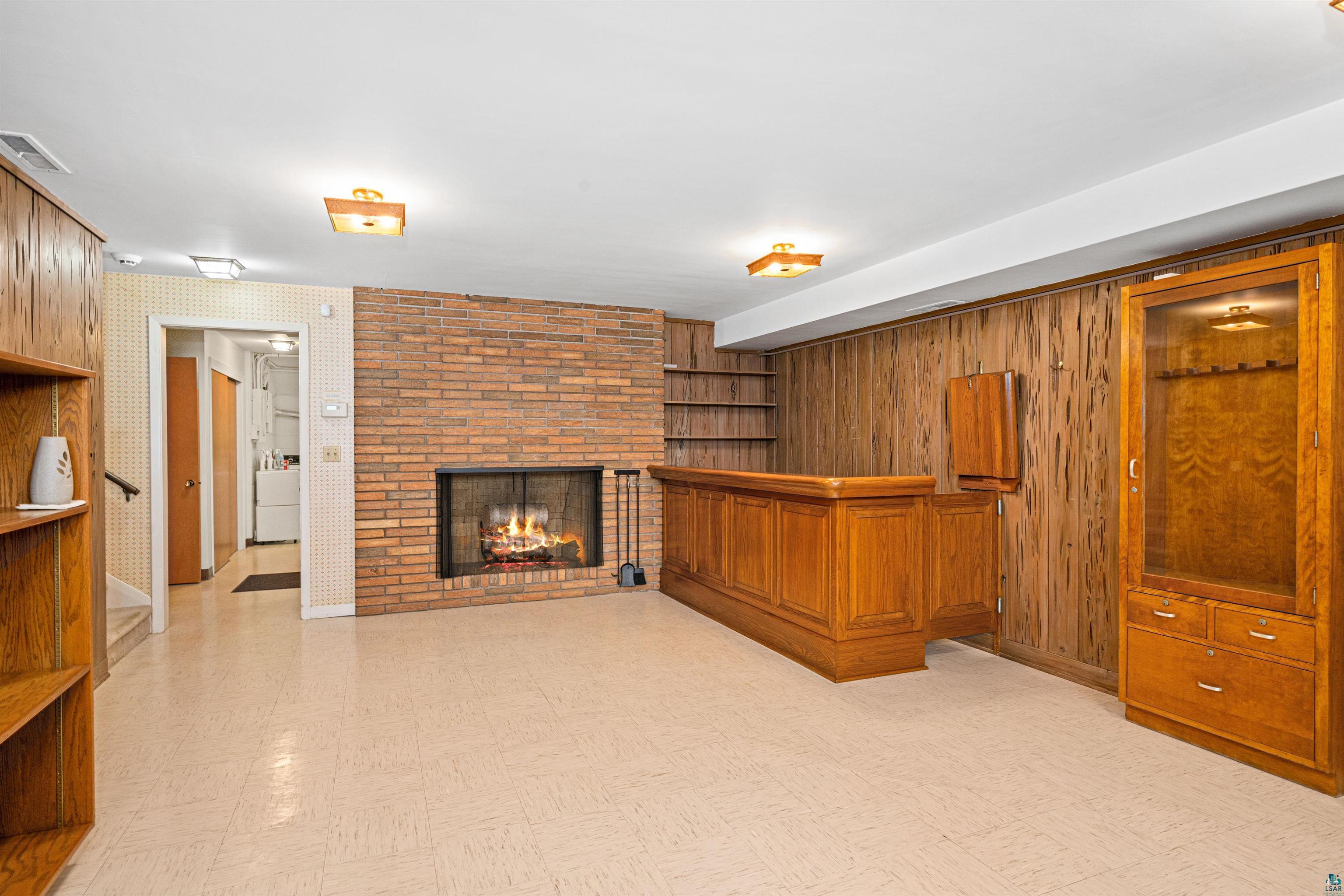 5781 South Pike Lake Road Duluth, MN 55811 - Photo 20 of 42 Unfurnished living room featuring light floors and a fireplace