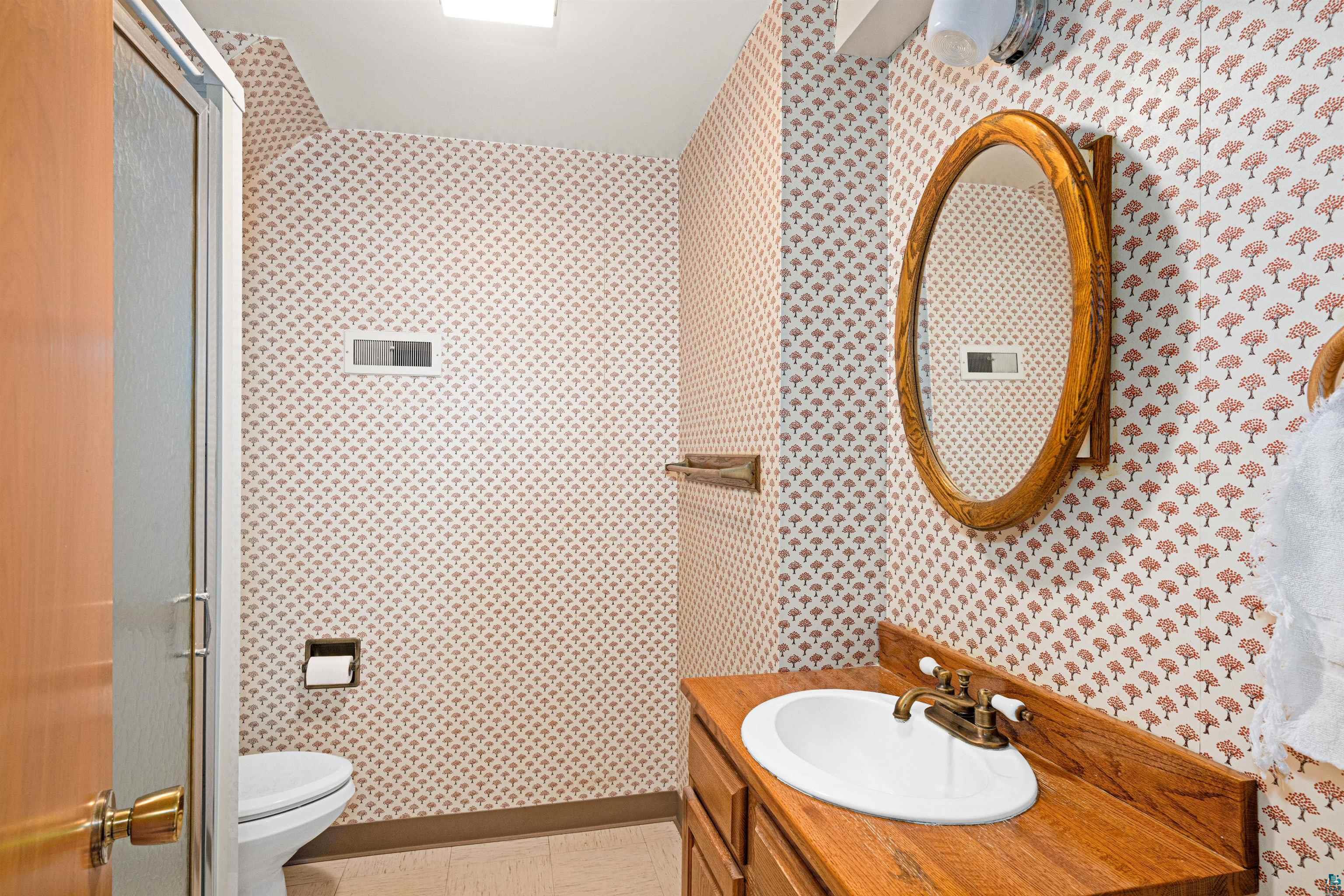 5781 South Pike Lake Road Duluth, MN 55811 - Photo 21 of 42 Bathroom featuring vanity, wallpapered walls, and a shower stall