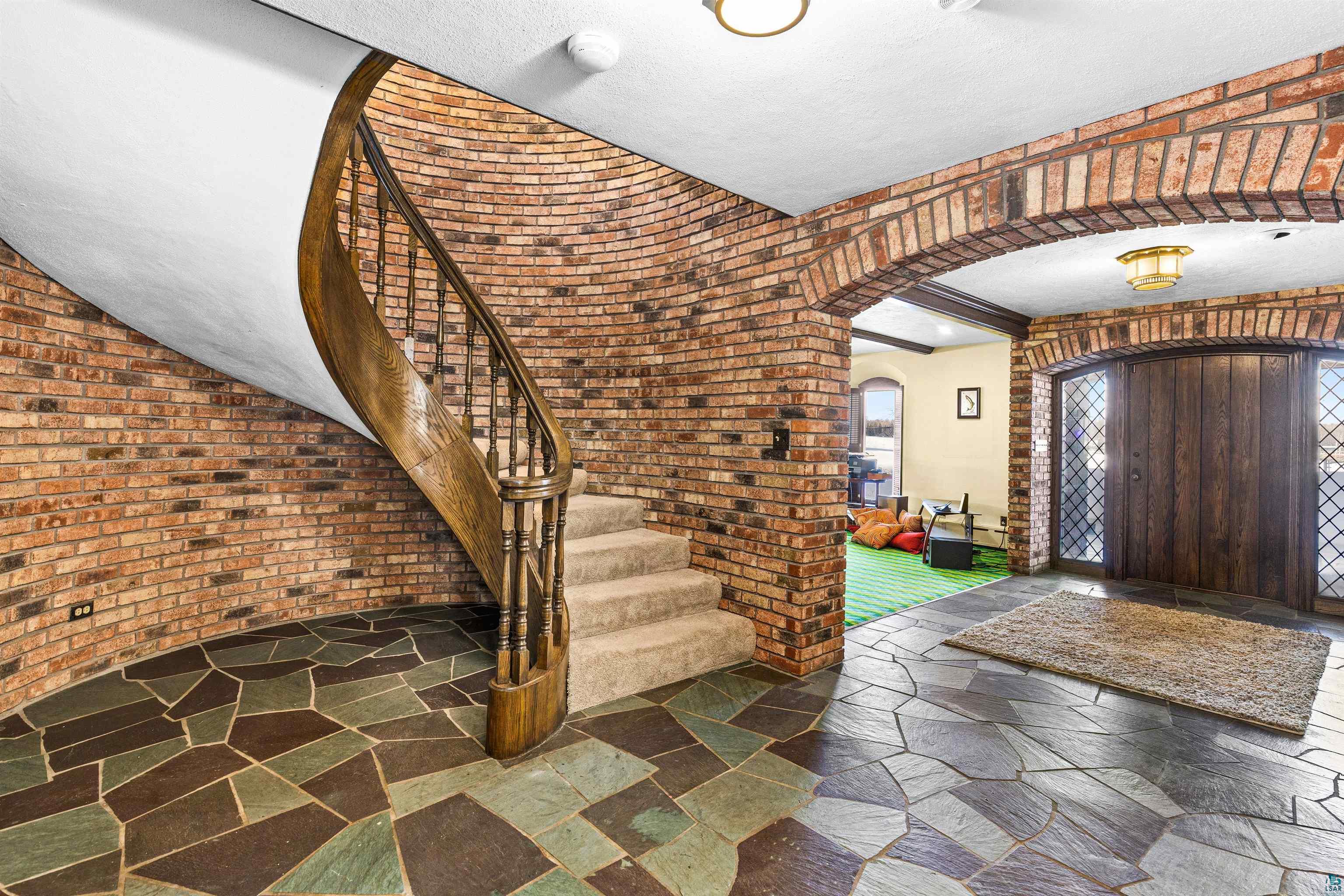 5781 South Pike Lake Road Duluth, MN 55811 - Photo 36 of 42 Entryway featuring arched walkways, stone tile flooring, and brick wall