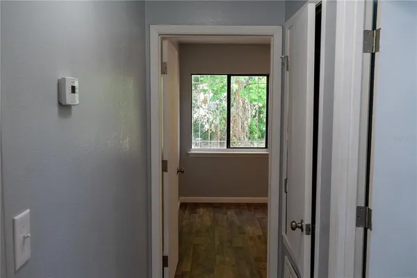 a view of a small space with wooden floor and chandelier fan