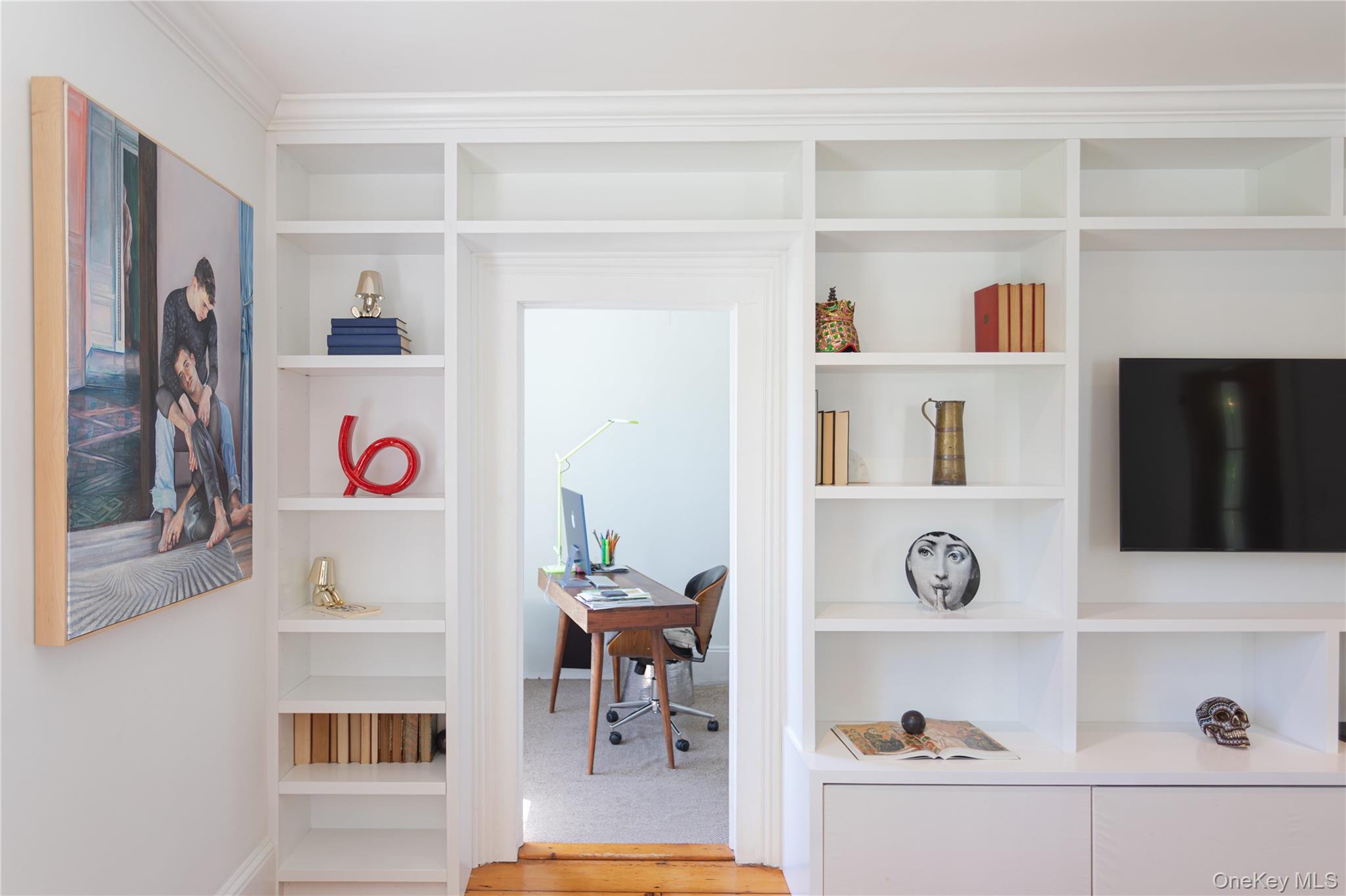 210 Middle Road Hudson, NY 12534 - Photo 16 of 42 Built-in custom shelving and cabinetry featuring crown molding, an integrated television mount, and a doorway opening to an additional room/studio