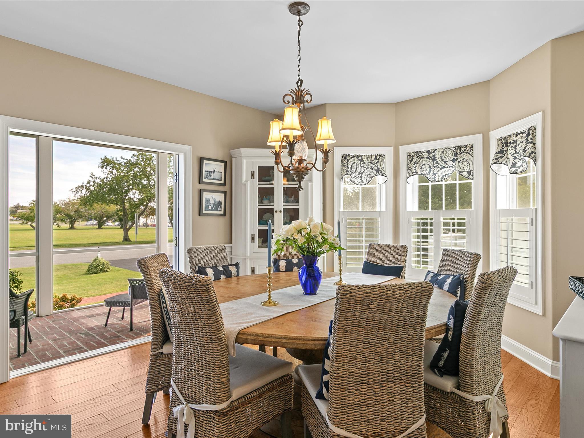 515 Stockley St Extension Rehoboth Beach, DE 19971 - Photo 19 of 104 a dining room with wooden floor a chandelier a glass table and chairs