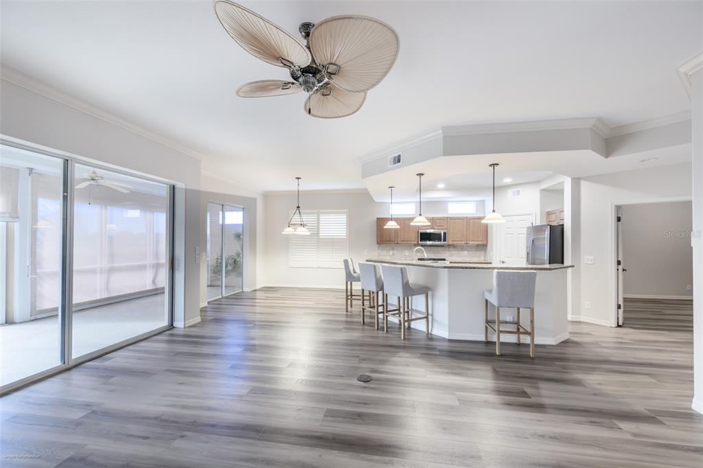 3959 San Rocco Drive, Unit 612 Punta Gorda, FL 33950 - Photo 8 of 41 a kitchen with stainless steel appliances kitchen island granite countertop a table chairs in it and wooden floors