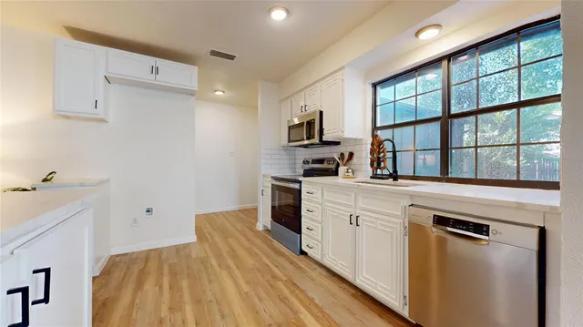 a kitchen with white cabinets and white appliances