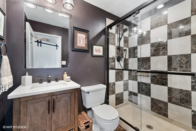 a bathroom with a sink a toilet and shower