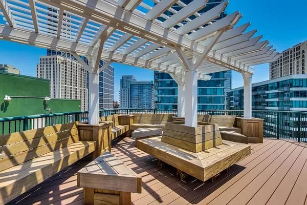 a view of a patio with couches table and chairs with wooden floor and fence