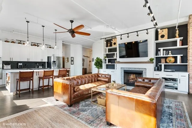 a living room with furniture a flat screen tv and a fireplace
