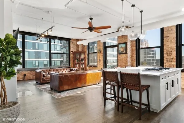 a kitchen with a stove kitchen island and couches with wooden floor