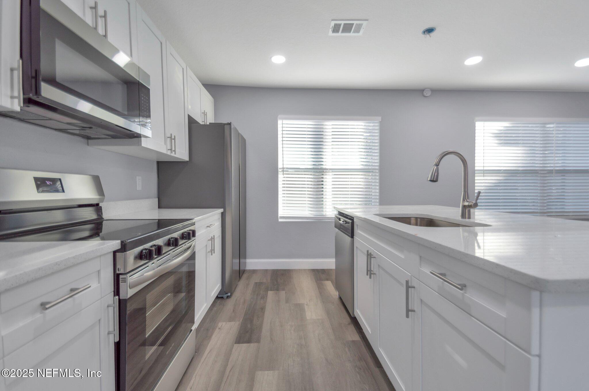 1759 Planters Road Jacksonville, FL 32207 - Photo 3 of 16 a kitchen with stainless steel appliances granite countertop a stove a sink and a refrigerator