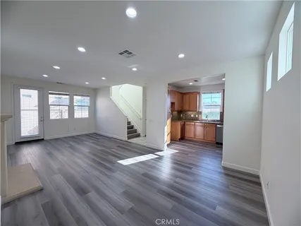 a view of a big room with wooden floor and windows