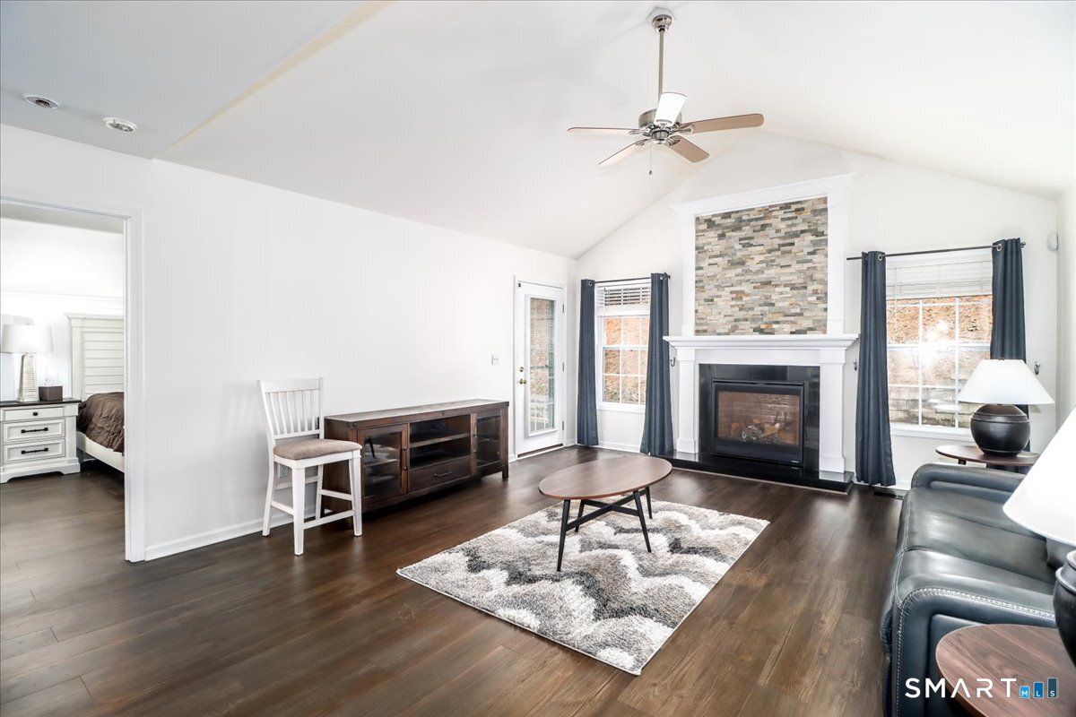 87 Haley Lane, Unit 87 Newtown, CT 06482 - Photo 15 of 39 a living room with furniture a fireplace and a floor to ceiling window