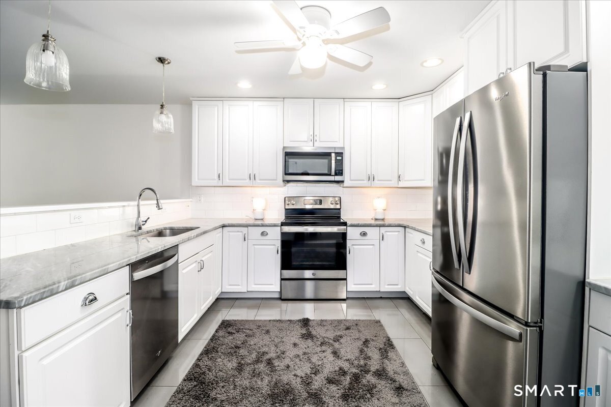87 Haley Lane, Unit 87 Newtown, CT 06482 - Photo 4 of 39 a kitchen with granite countertop a refrigerator and a sink