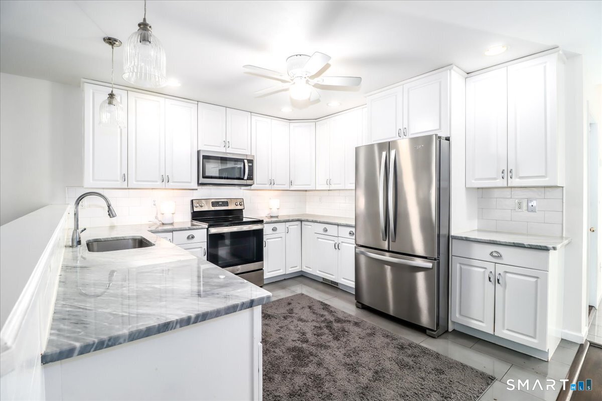 87 Haley Lane, Unit 87 Newtown, CT 06482 - Photo 6 of 39 a kitchen with granite countertop a refrigerator oven a sink and dishwasher