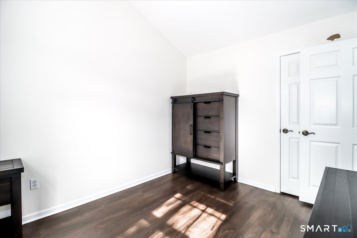 87 Haley Lane, Unit 87 Newtown, CT 06482 - Photo 7 of 39 a view of an empty room and wooden floor