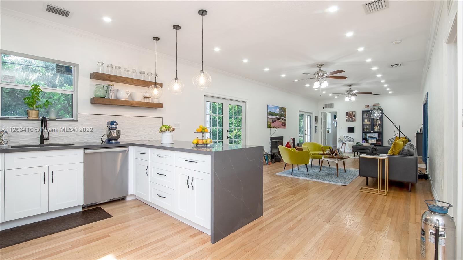 635 Bird Road Coral Gables, FL 33146 - Photo 16 of 35 a large white kitchen with lots of counter space and stainless steel appliances