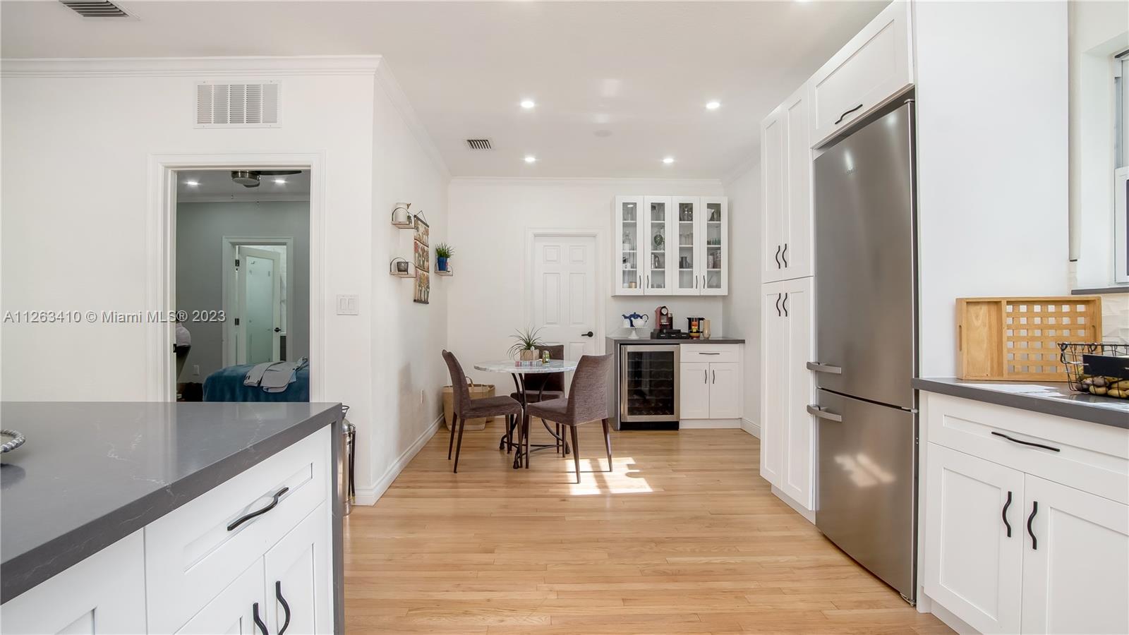 635 Bird Road Coral Gables, FL 33146 - Photo 18 of 35 a kitchen with granite countertop cabinets a refrigerator a counter space and stainless steel appliances
