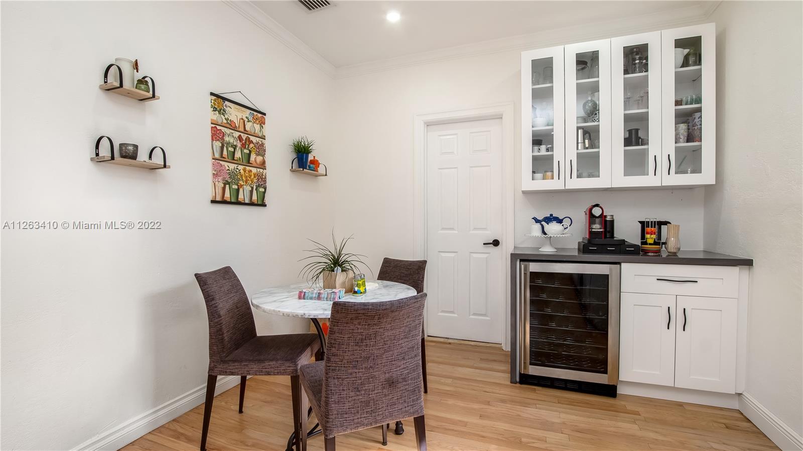 635 Bird Road Coral Gables, FL 33146 - Photo 19 of 35 a kitchen with a dining table chairs and cabinets