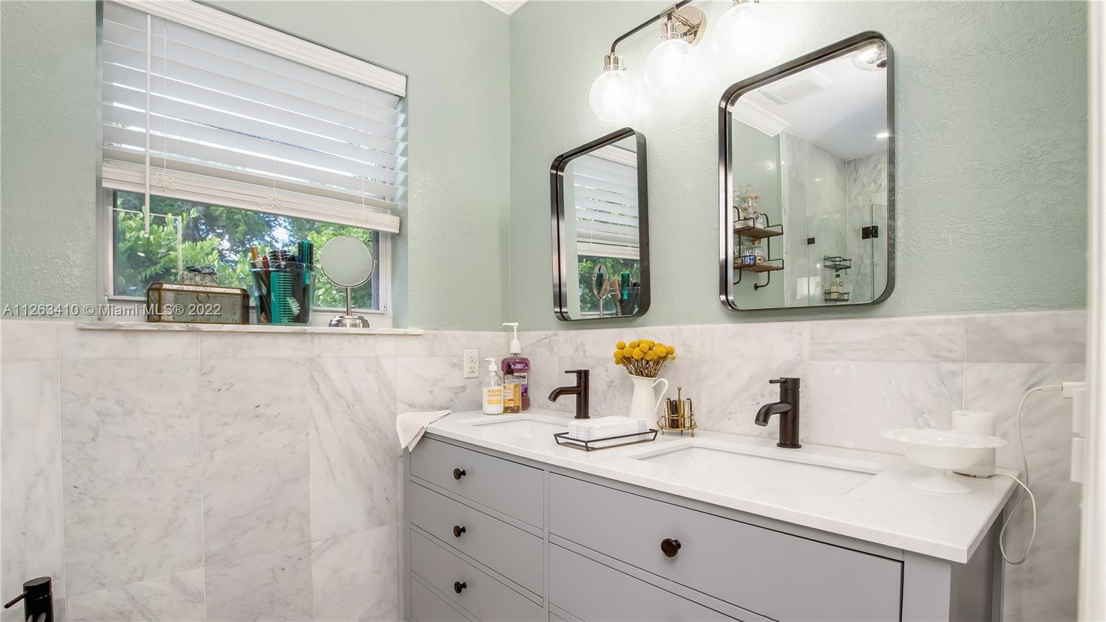 635 Bird Road Coral Gables, FL 33146 - Photo 25 of 35 a bathroom with a sink and a mirror