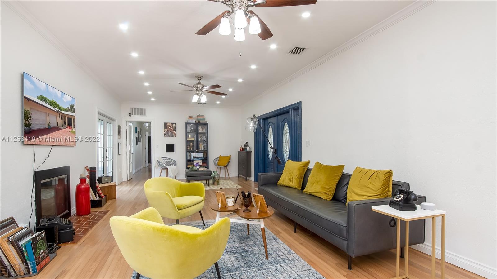 635 Bird Road Coral Gables, FL 33146 - Photo 10 of 35 a living room with furniture a flat screen tv and a fireplace