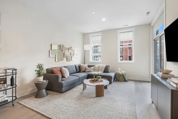 a living room with furniture a flat screen tv and a window