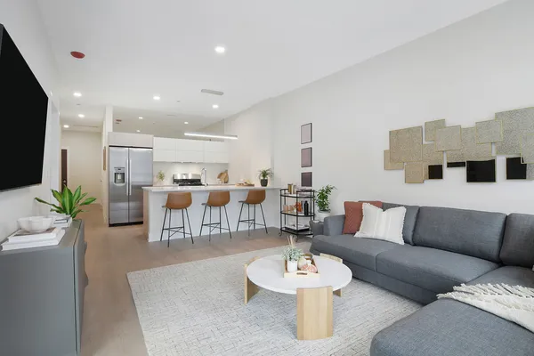a living room with furniture and a dining table with kitchen view