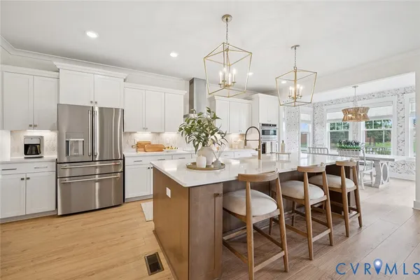 a kitchen with stainless steel appliances a dining table chairs and chandelier