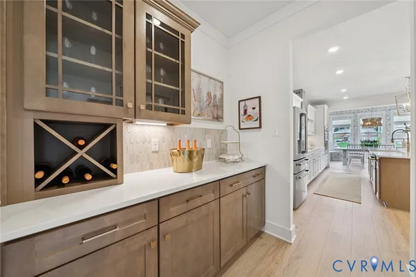 a kitchen with stainless steel appliances granite countertop a refrigerator a sink a stove and white cabinets with wooden floor