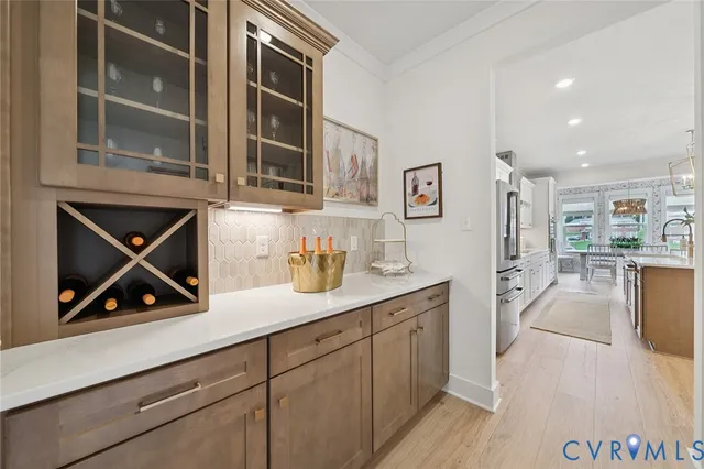 a kitchen with stainless steel appliances granite countertop a refrigerator a sink a stove and white cabinets with wooden floor