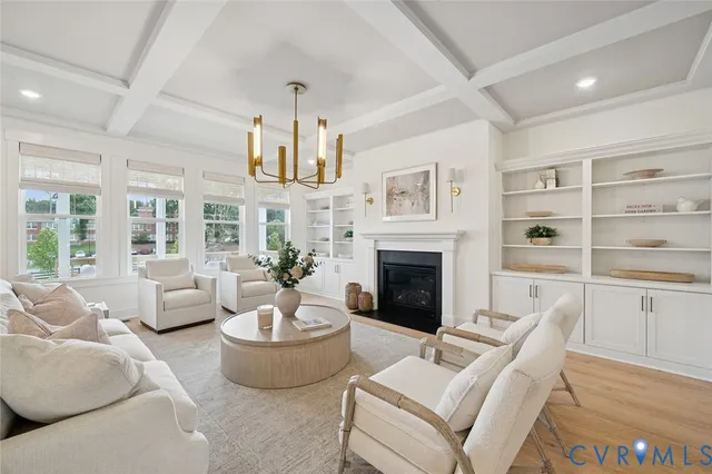 a living room with furniture a fireplace and a chandelier