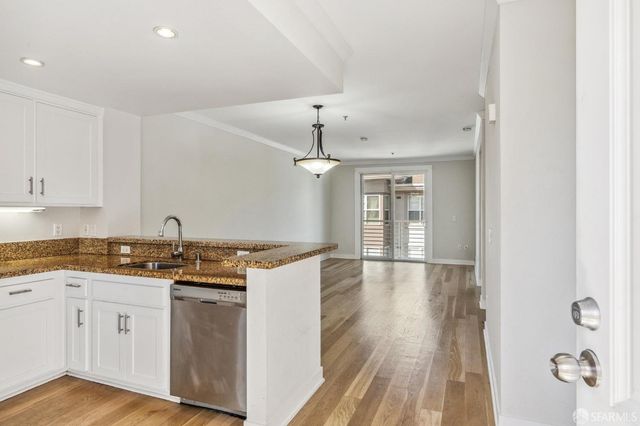 a kitchen with granite countertop a stove top oven and cabinets