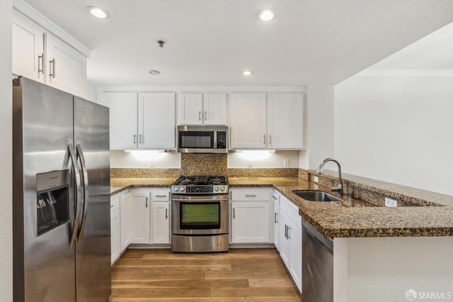 a kitchen with stainless steel appliances granite countertop a sink stove and refrigerator