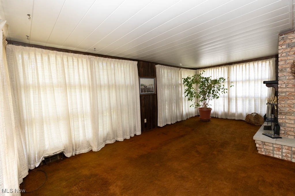 7312 Ivandale Road Independence, OH 44131 - Photo 15 of 44 Unfurnished living room featuring brick wall and carpet