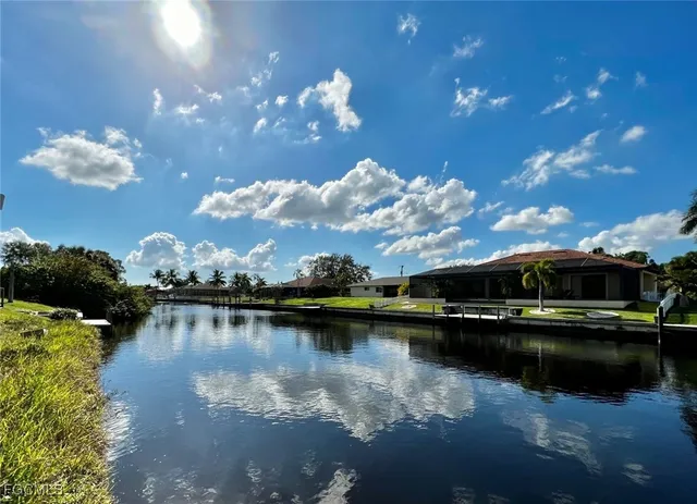 a view of a lake with lawn chairs