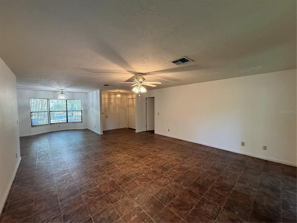 9231 Southwest 197th Circle Dunnellon, FL 34432 - Photo 3 of 12 an empty room with windows and ceiling fan