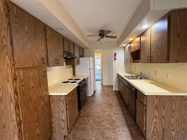 a kitchen with stainless steel appliances a sink stove and cabinets
