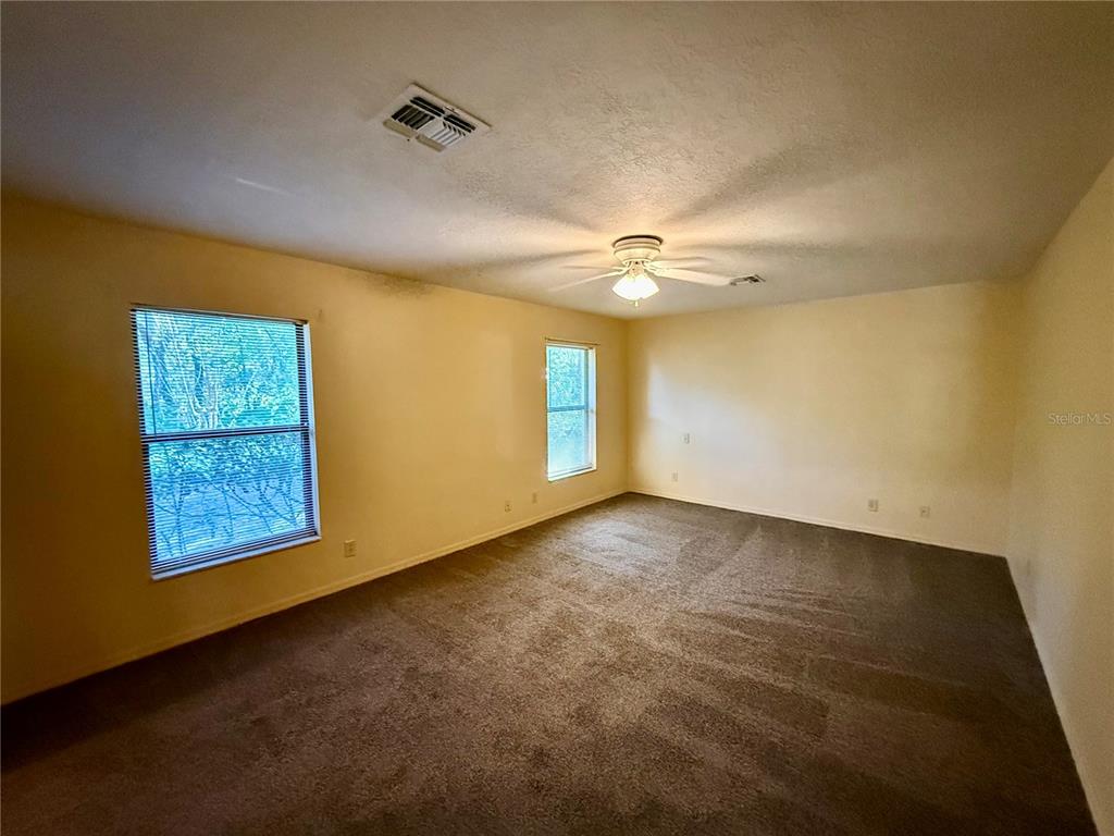 9231 Southwest 197th Circle Dunnellon, FL 34432 - Photo 6 of 12 an empty room with windows and fan